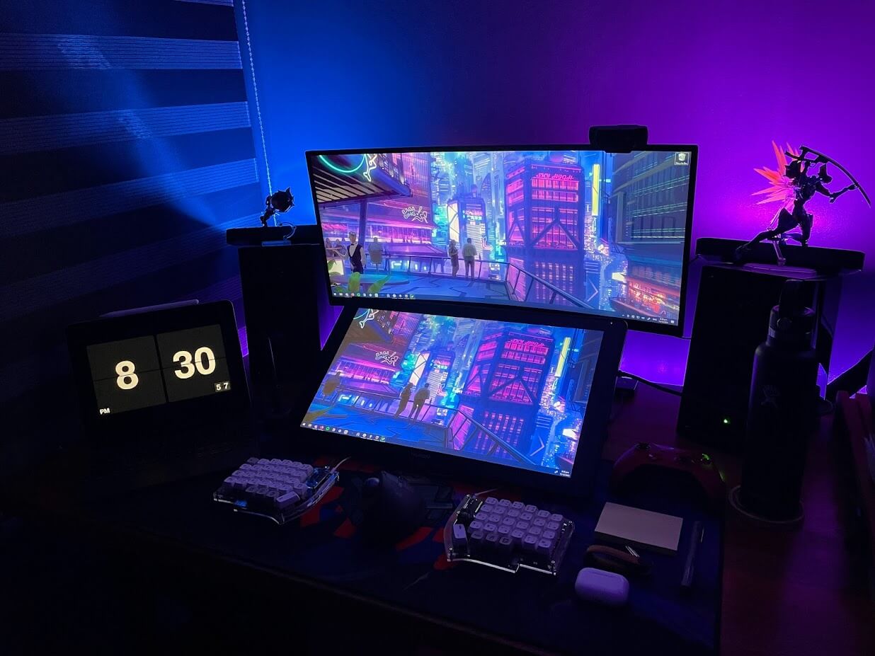 Photo of Sam's workspace, shows monitors and keyboard